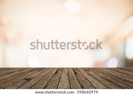 old vintage retro brown wood tabletop with blurred abstract store mall bokeh light warm tone background boarder:grunge aged wooden with blurry orange color backdrop.show advertise product on display