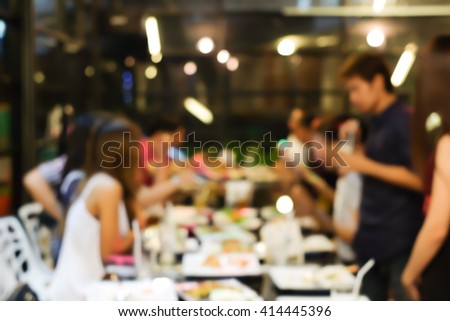 abstract blurred group of asian casual family meeting in the restaurant background:blurry of caucasian people have fun night party after working concept:blur lifestyle manner.holiday vacation weekend