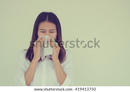close up asian woman got a cold:young girl holding tissue in hand for reaction sneezing :healthcare concept.runny nose:sore or scratchy throat:risk of life:severe allergies:vintage tone filter effect