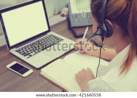 close up call centre woman work in office room:focus on headphone girl response answer customer question partner concept:people hotline job career:services support business:telecom operation employee