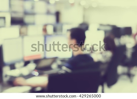 blurred woman/man operator working or searching on computer at office room:blur of woman monitoring and talking on headphone concept:blurry of people,business,technology :call centre help desk concept