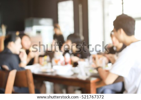 abstract blurred group of asian friends meeting in the restaurant background:blurry of caucasian people having fun before go to working concept:blur lifestyle manner conceptual.friendship conception.