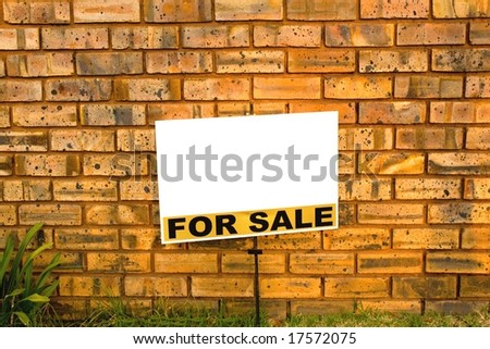 for sale sign in front of a brick wall