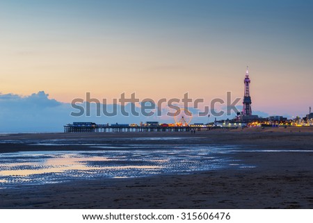 Late evening after sunset in Blackpool beach ,England, UK. Pier with attraction in background.