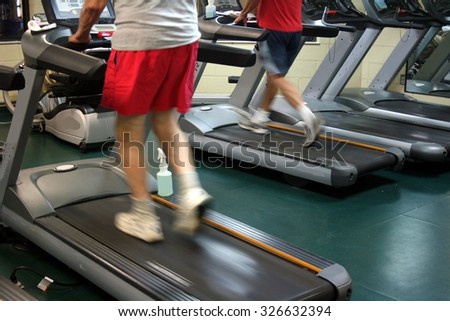 A person walking a treadmill with red shorts and a white top