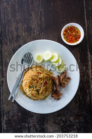 A Thai dish of chicken fried rice presented on a square white plate.