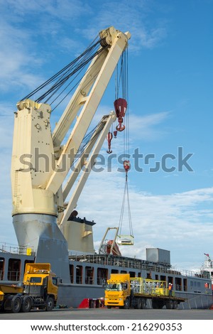 Cranes unloading a ship in a harbor