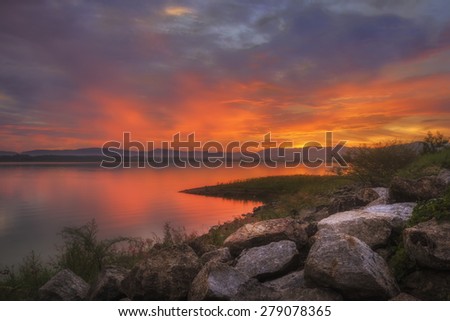 Colorful sunset at the rocks and Silhouettes landscape view sunset Water reflection,rayong thailand
