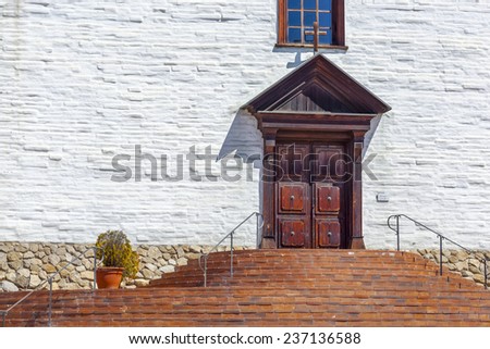 Detail of a Spanish colonial mission church showing the front door and stairs.