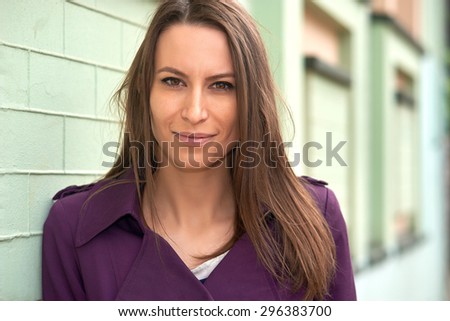 Portrait of a smiling young woman close up on a background of the urban landscape