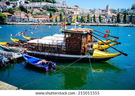 PORTO, PORTUGAL - AUGUST 6: A man rests on his boat next to some traditional rabelo boats on August 6th, 2014 in Porto, Portugal.