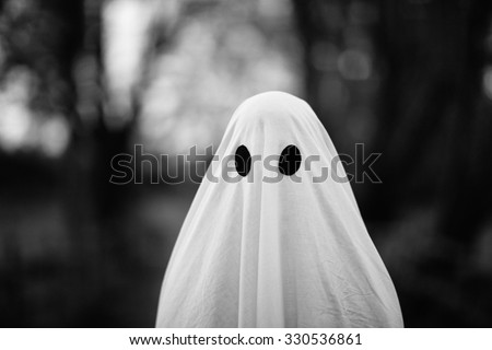 Portrait of ghost covered with a white ghost sheet. Grainy textured image to add vintage look.