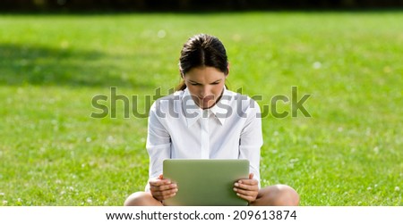 Woman sitting with a computer on the grass, businesswomen, female success, woman working / Woman at work