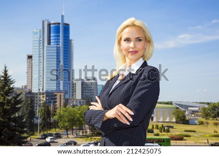 beautiful business woman on the sky background in a dark suit.