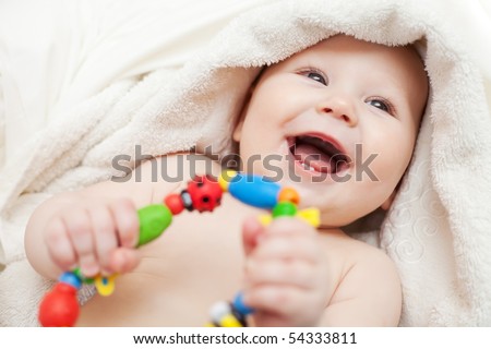 Small smiling baby with a toy