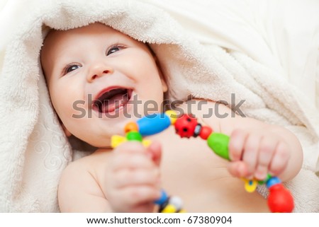 Small smiling baby with a toy