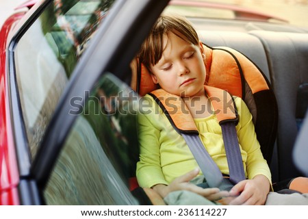 a small girl sleeps in car