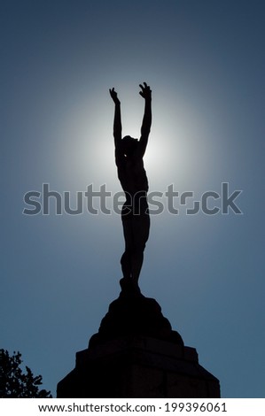 Icarus backlit statue holding the sun