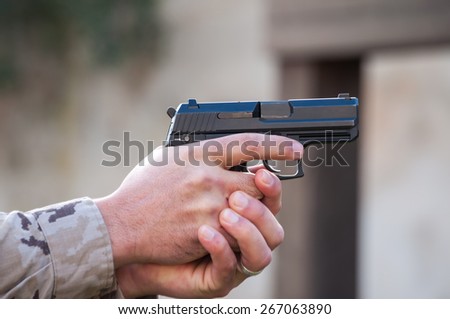 man pointing gun gripped with both hands