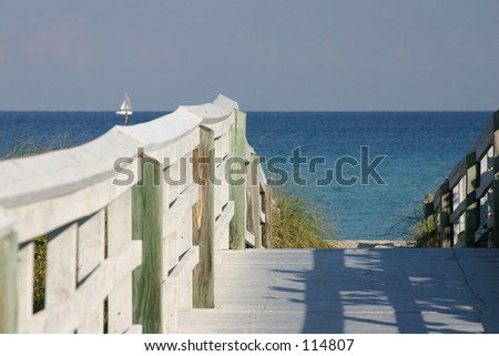 deck to the beach with sailboat on the ocean