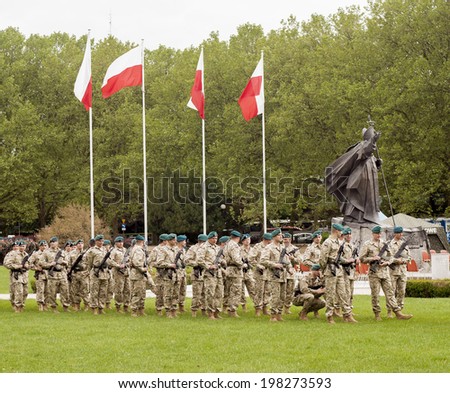 SZCZECIN, POLAND - MAY 29, 2014: Veterans Day in Poland. Polish army soldiers, with machine guns preparing to parade.It also has polish flags and Memorial of Blessed John Paul II.