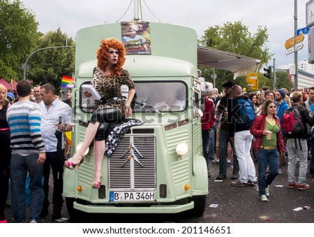 BERLIN, GERMANY - JUNE 21, 2014:Christopher Street Day.Crowd of people Participate in the parade gays,lesbians,bisexuals.Prominent in the image a elaborately dressed transgender sitting on car.