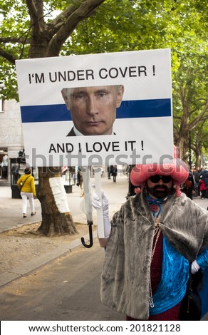 BERLIN, GERMANY - JUNE 21, 2014: Christopher Street Day.Prominent in the image a Elaborately dressed participant holds a placard with a slogan over the face of Russian President Vladimir Putin.