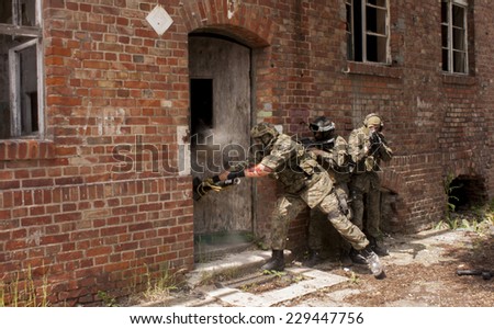 SZCZECIN, POLAND - MAY 31, 2014: Three soldiers in full uniform stormed the building, during historical reconstruction