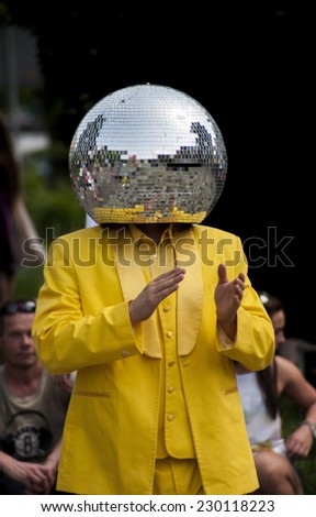 Szczecin, Poland - Mai 23, 2014: Juwenalia, is an annual students\' holiday in Poland, usually celebrated for three days in late May. Disco Ball Man in a yellow dress, dancing in the street.