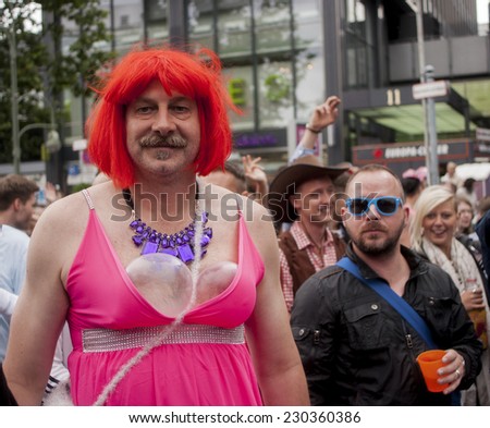 BERLIN, GERMANY - JUNE 21, 2014: Christopher Street Day. Crowd of people Participate in the parade celebrates gays, lesbians,  and transgenders. Prominent in the image, elaborately dressed transgender
