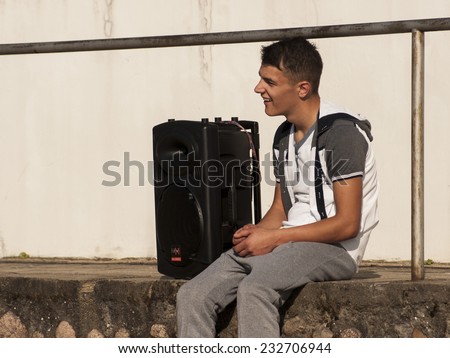 WAGRAWIEC, POLAND - JUNE 21, 2014: Young man with speaker during shooting music video clip of the polish Disco band Jurad