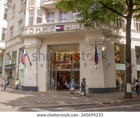 BERLIN, GERMANY - MAY 30, 2014: Pedestrians walk past a Tommy Hilfiger store. Tommy Hilfiger is an American fashion, apparel, design, fragrance retail company