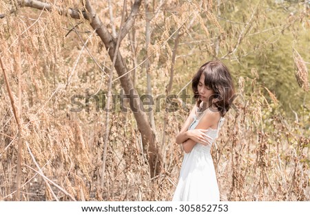 asia women white dresses lonely and isolated in deserted forest - selective focus point at face,tone image wasteful