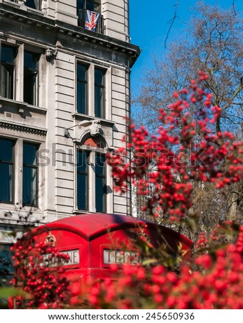 A British flag hangs in a window with a red telephone box in the foreground.
