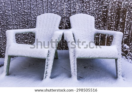Two snow covered lawn chairs.