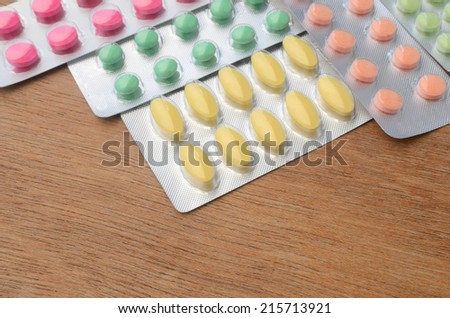 Close up colorful of medicine tablets and capsules on wood background