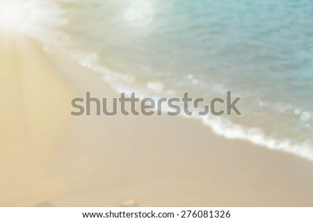 Beach background.Blurred smooth wave and sand with sun light