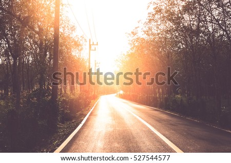 Sunset country road. Travel adventure and transportation concept. Vintage tone filter color style.