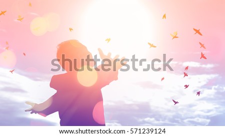 Freedom feel good and travel adventure concept. Copy space of silhouette man rising hands on sunset sky double exposure colorful bokeh and bird fly background. Vintage tone filter effect color style.