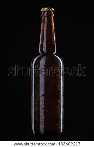 Beer bottle with water drops isolated on black
