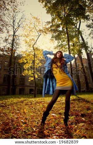 Woman in blue jacket posing in autumn park