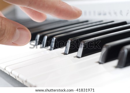 hand playing music on the piano
