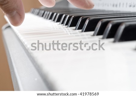 hand playing music on the piano