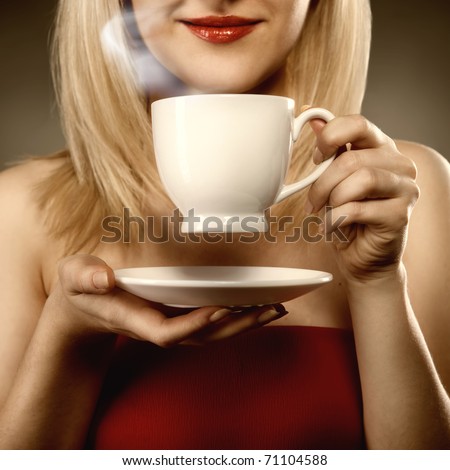 woman in red holding cup and smiles