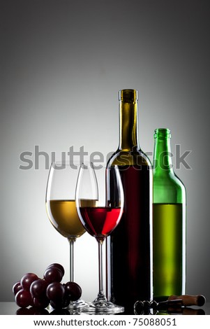 Red and white wine in glasses with grape and bottles