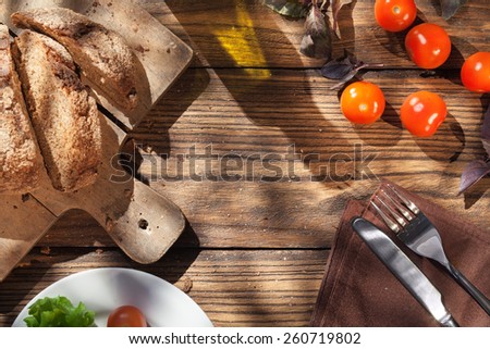 Top view of italian food on wooden table - bread, olive oil and tomatos with basil