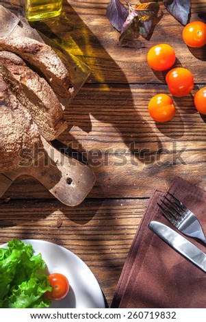 Top view of italian food on wooden table - bread, olive oil and tomatos with basil