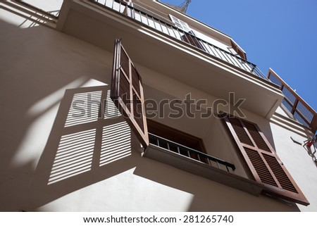 Open wooden window in hot summer day with shadow on the wall