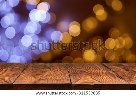 wooden table with yellow holiday lights on background