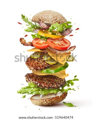 Delicious monster burger with flying ingredients isolated on white background